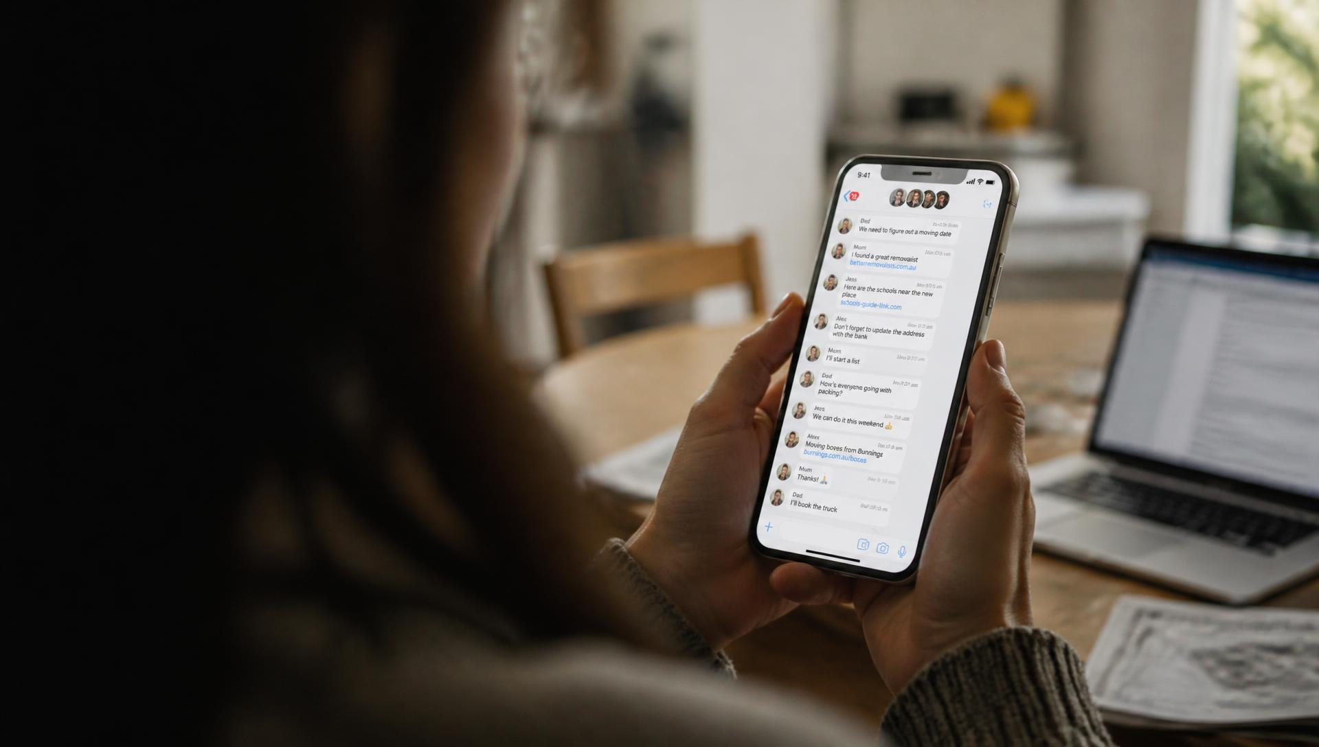 Hands holding a phone showing a busy family group chat full of forwarded links and conflicting advice